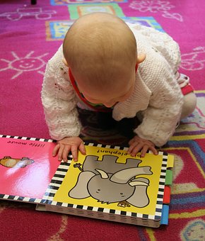 бебе разглежда детска книжка със слонче